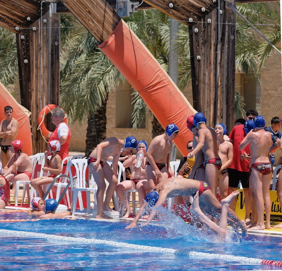 Jugadores saltando al agua en un torneo interclubs al aire libre